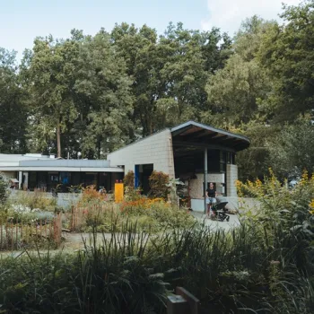 Natuur- en Milieucentrum Weert met gebouw en tuin, omringd door groen en bomen.